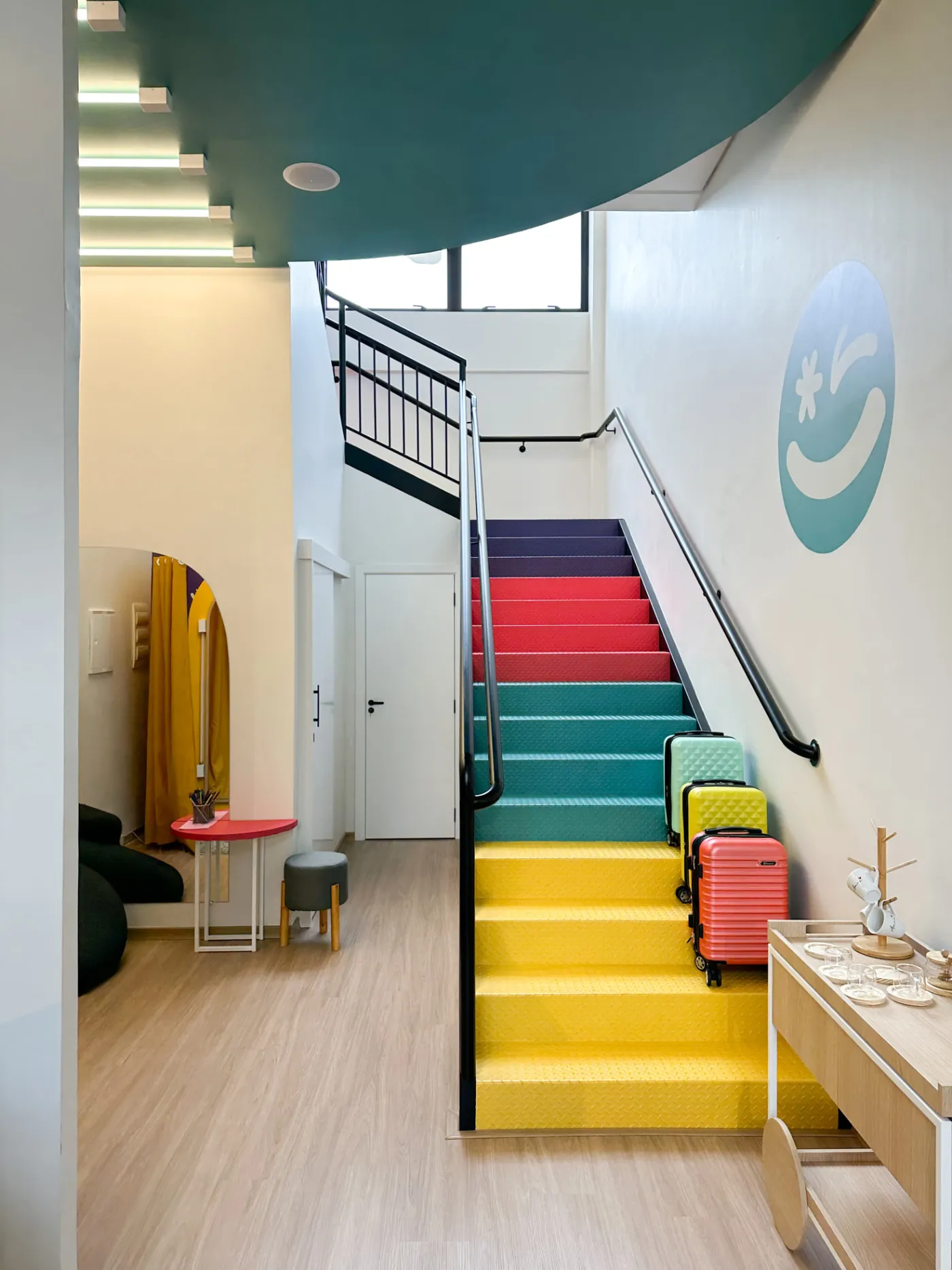 Ambiente comercial com escada colorida, poltronas e objetos de design
