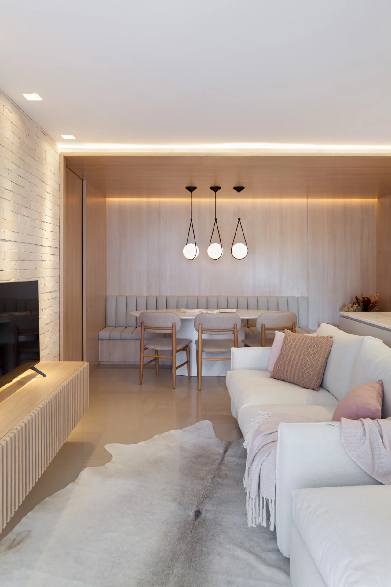 Living integrado com sala de jantar, marcenaria clara e iluminacao embutida