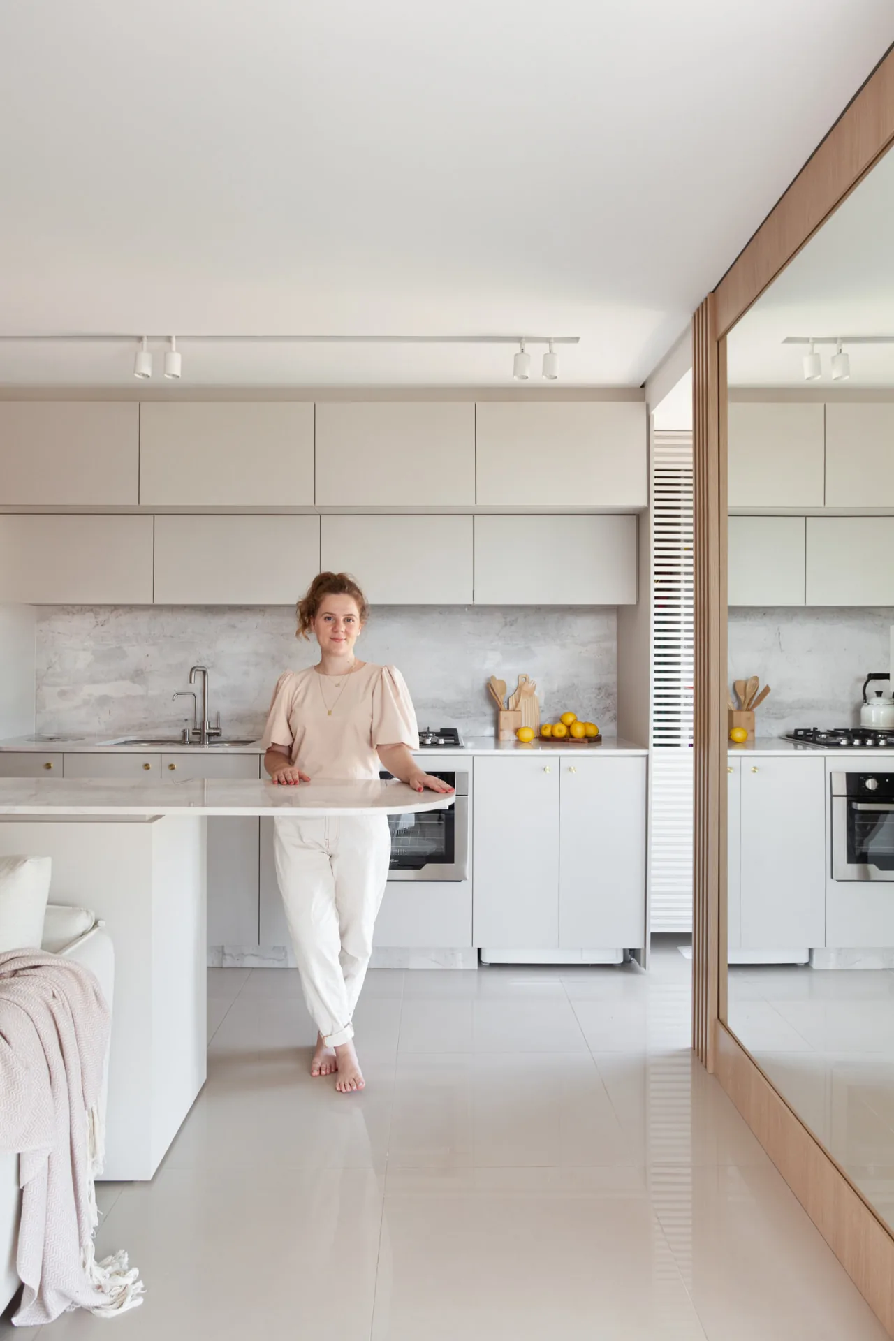 Mônica Backes apoiada na bancada de mármore da cozinha do próprio apartamento