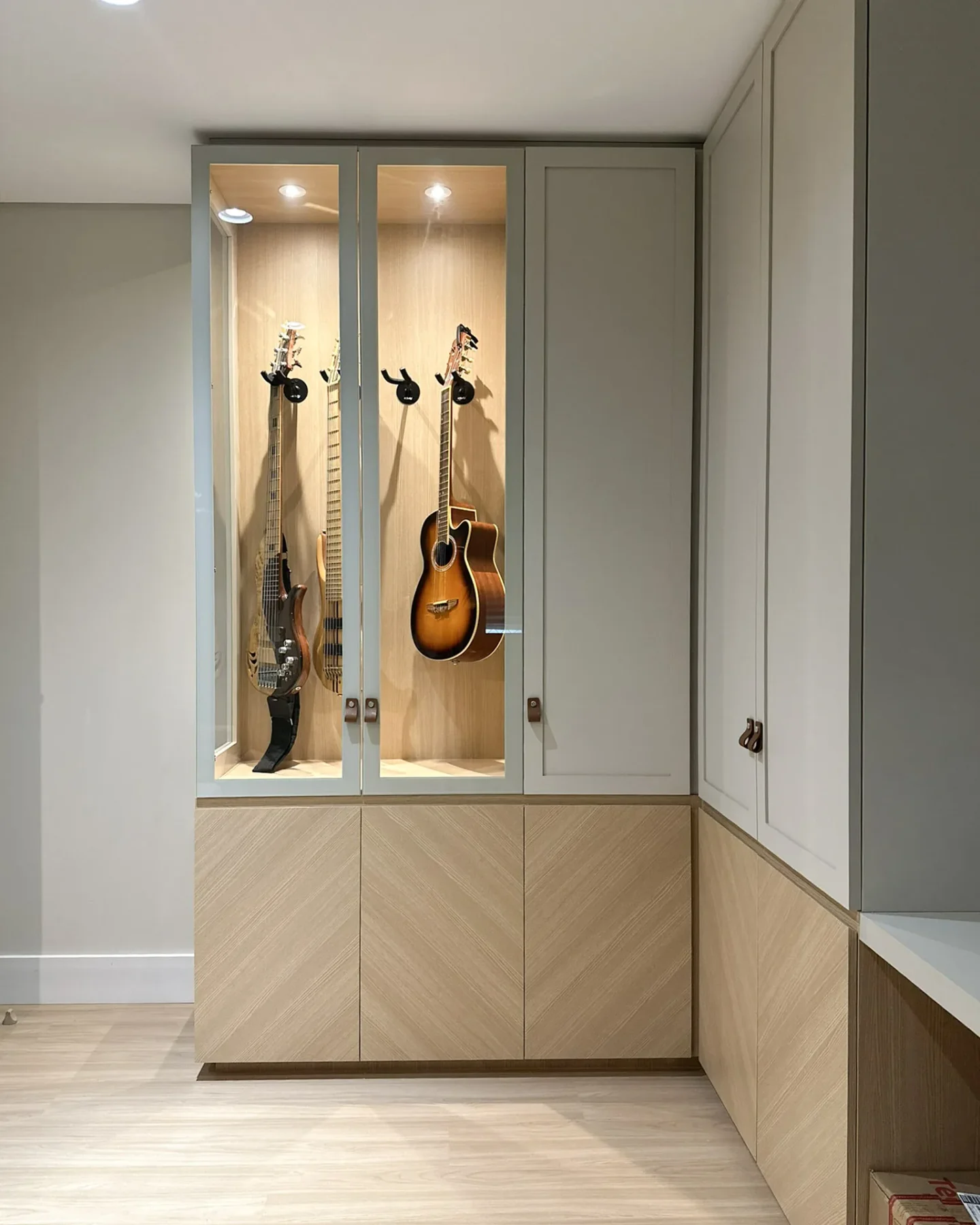 Cristaleira iluminada com instrumentos musicais, marcenaria em madeira e verde acinzentado